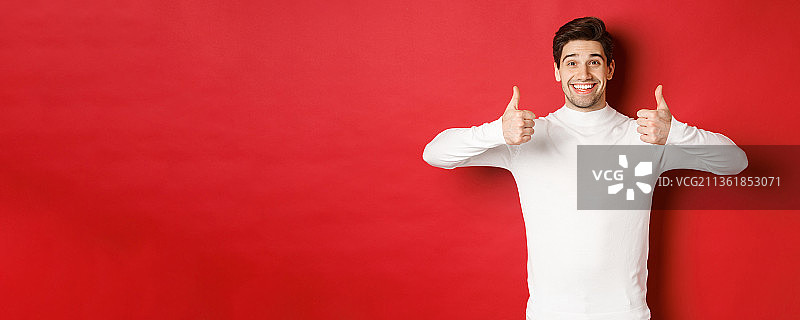 身穿白色毛衣，竖起大拇指的英俊男模特图片素材