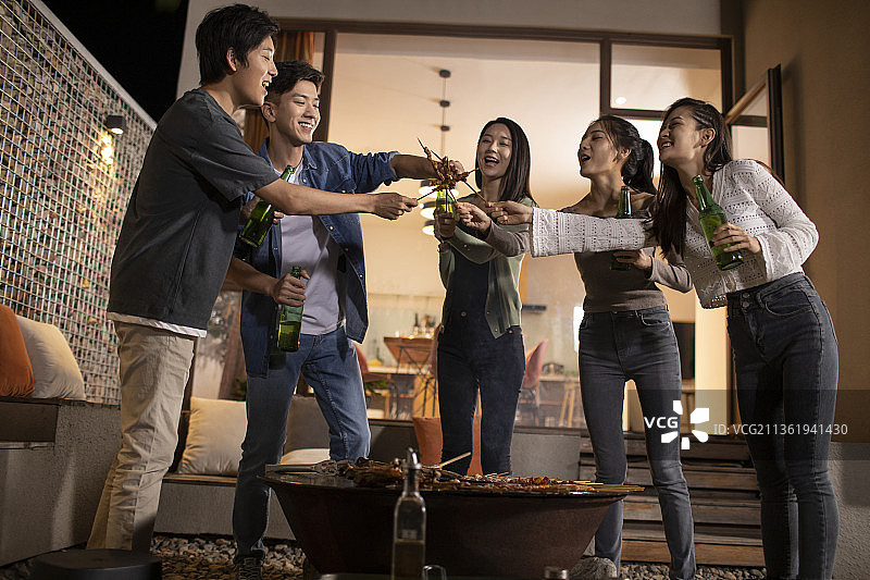 年轻朋友在庭院里烧烤聚餐图片素材