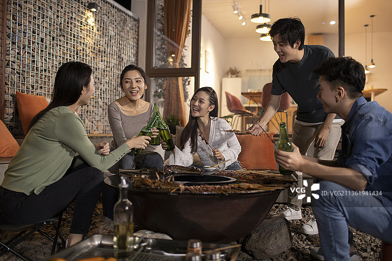 年轻朋友在庭院里烧烤聚餐图片素材