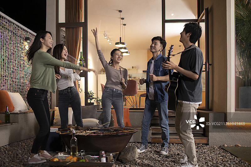 年轻朋友在庭院里烧烤聚餐图片素材