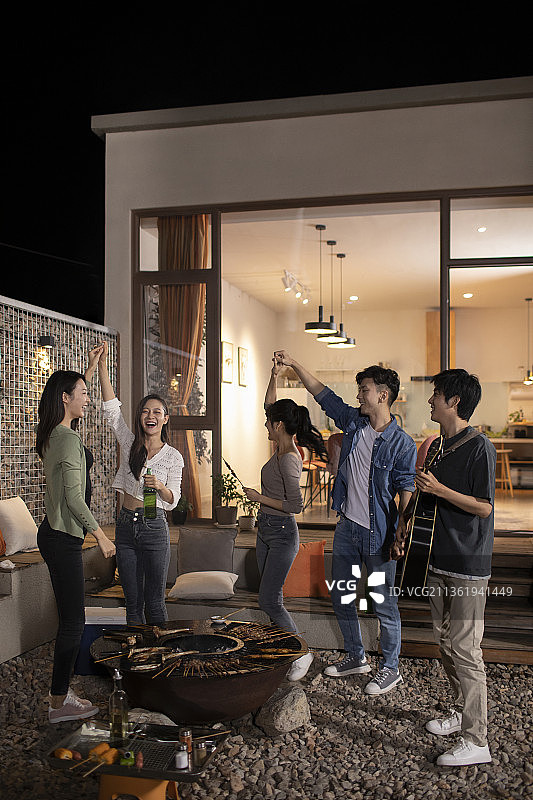 年轻朋友在庭院里烧烤聚餐图片素材