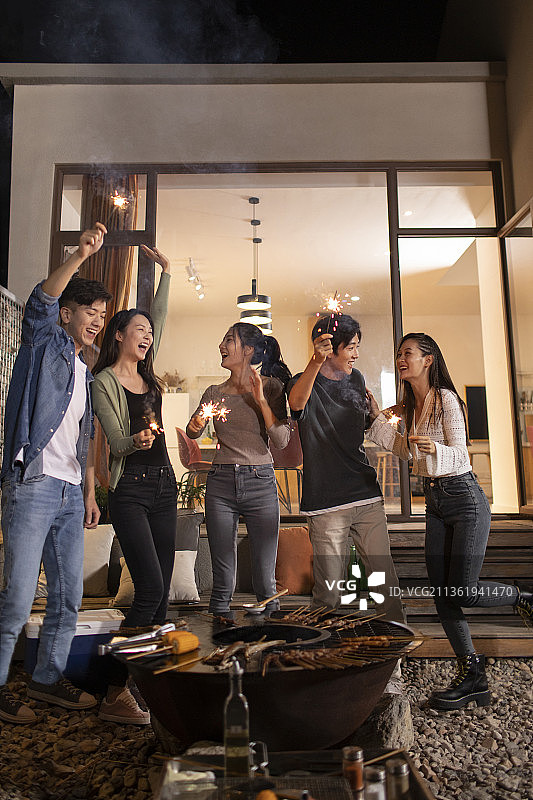 年轻朋友在庭院里烧烤聚餐图片素材