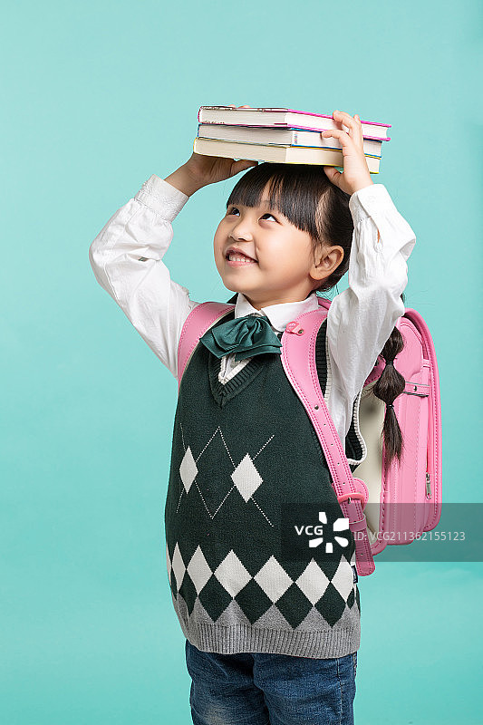 头顶一摞书的小学生图片素材