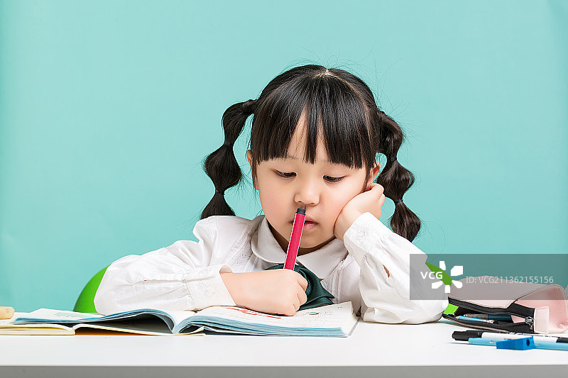 低头写作业的小学生图片素材