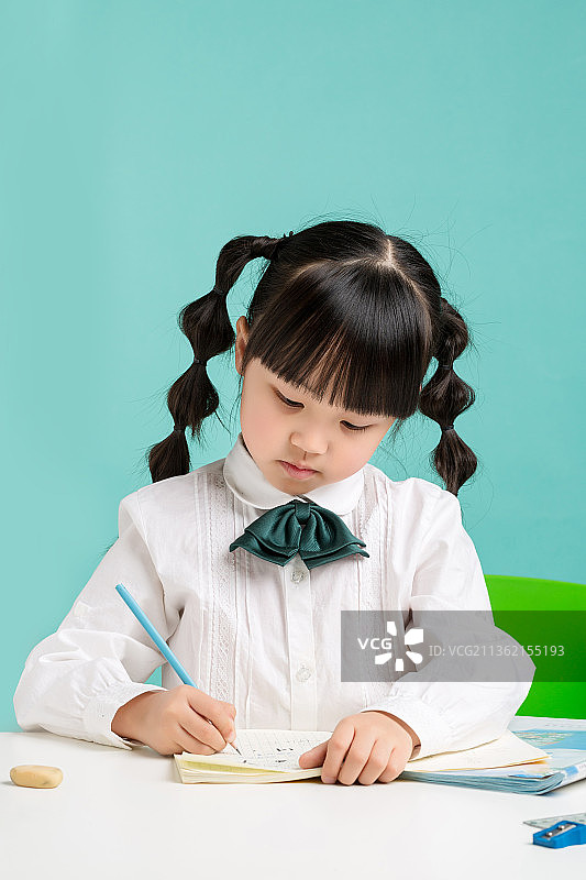 低头写作业的小学生图片素材