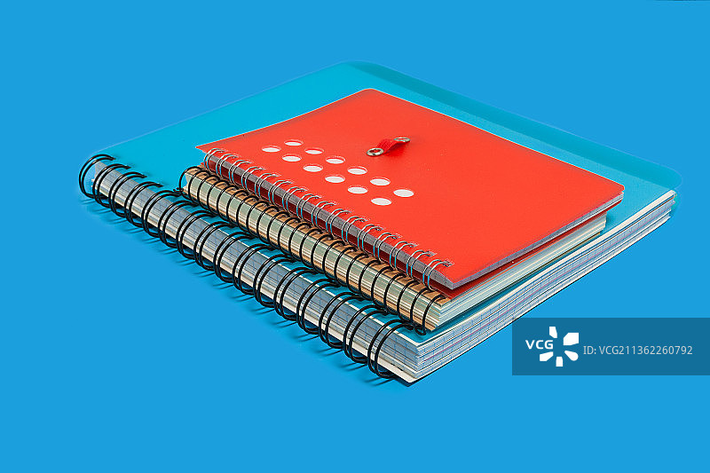 蓝色背景上的笔记本堆图片素材