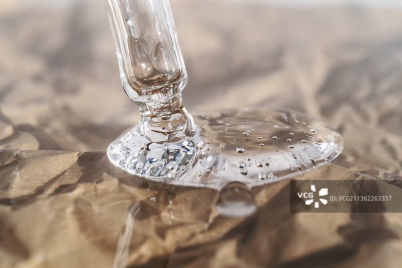 米色背景下用滴管吸取的血清或油的质地图片素材