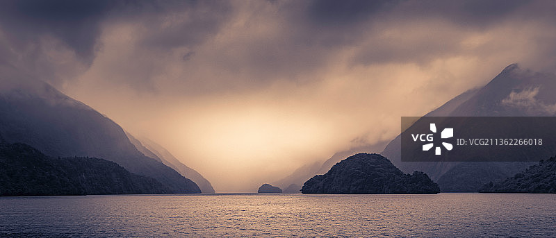 新西兰南岛Doubtful Sound的忧郁轮廓，日落时海景和山脉图片素材