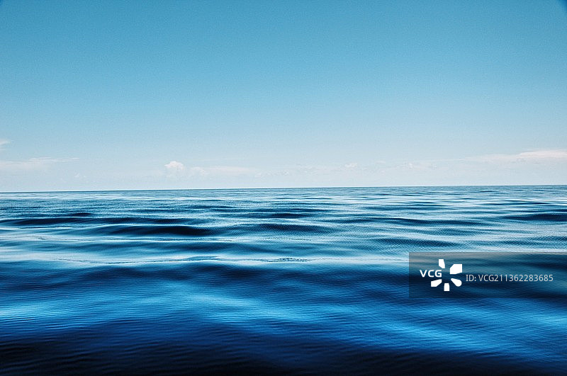 宁静水面，蓝色天空下的海景图片素材