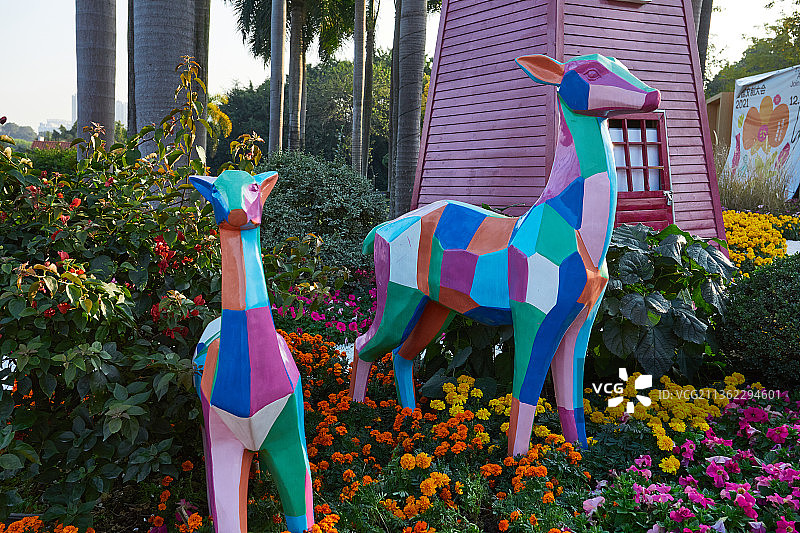 广州云台花园里蓝天下花丛中彩色风车旁的装饰品彩色小鹿图片素材