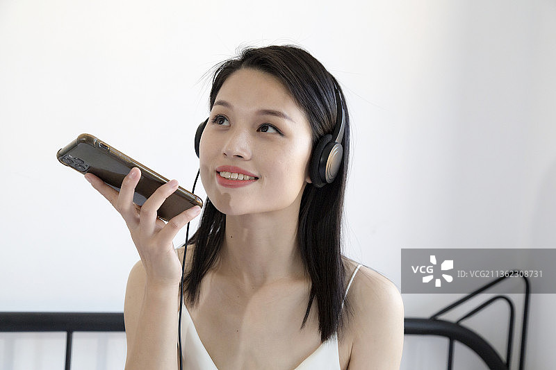 长头发的女人一边听音乐一边使用手机图片素材