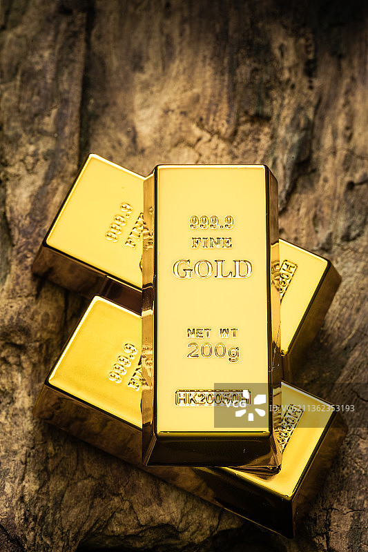 老木头上放着金条金砖黄金图片素材