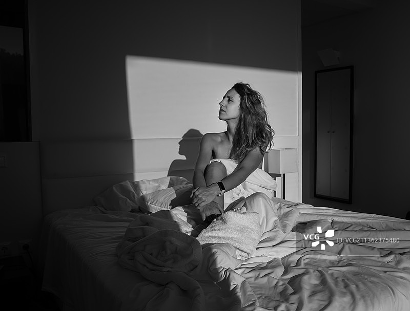 坐在家里的床上的女人图片素材