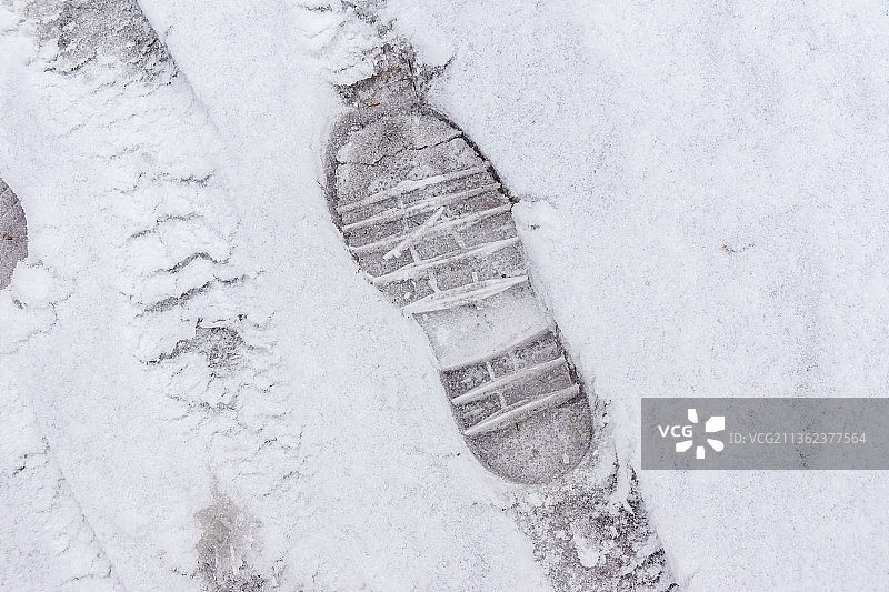 冬季鞋底十字图案的雪地印记图片素材