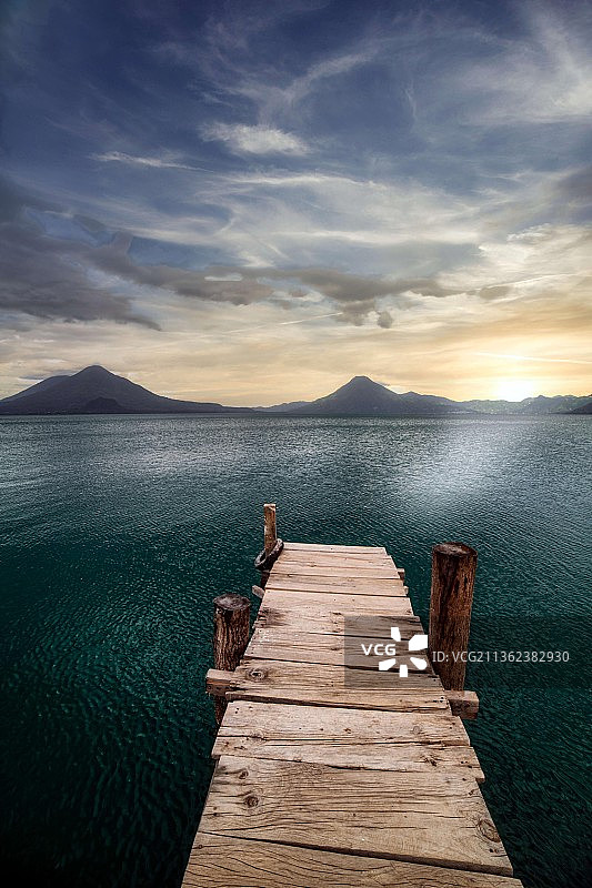 阿蒂特兰湖日落时分，危地马拉帕纳哈切尔，女子站在海边码头上图片素材