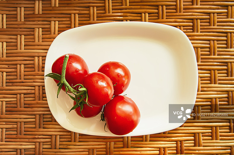 白色长方形盘子里的一簇红色樱桃番茄图片素材