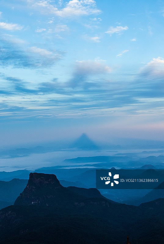 亚当峰的阴影：斯里兰卡日落时分山脉轮廓的壮丽景色图片素材