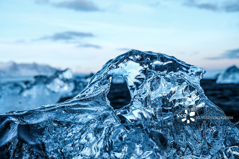 透明蓝色冰块，冰岛天空下的冰冻水特写图片素材