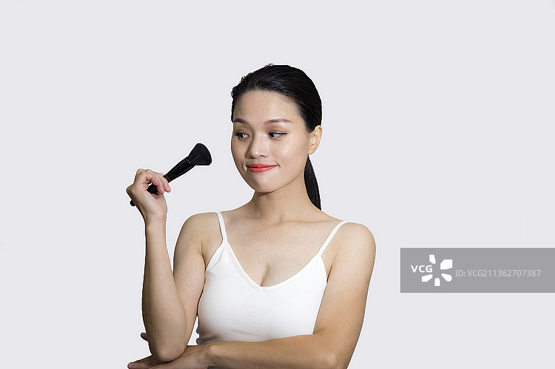 一名东方女性对着镜子化妆图片素材