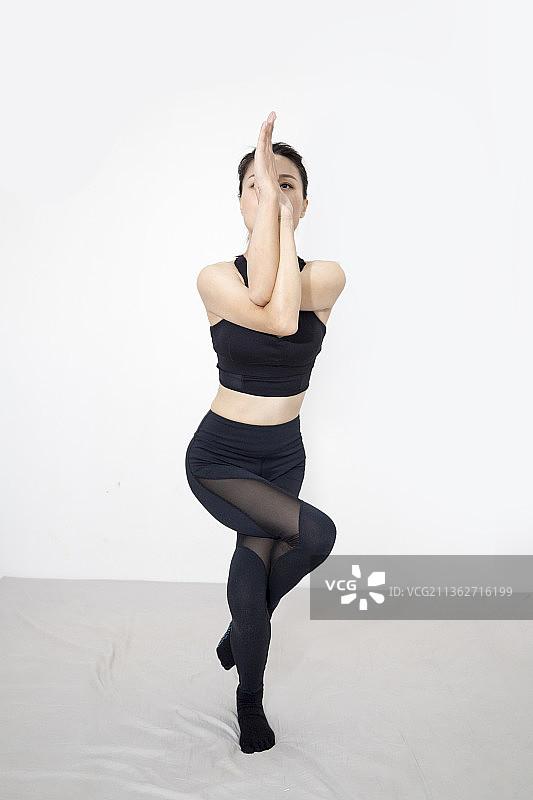 一名东方女人在室内做瑜伽运动图片素材