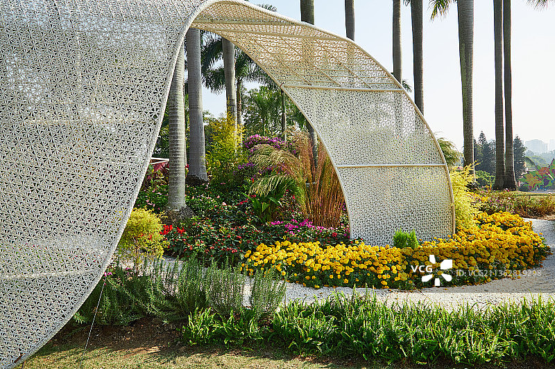 广州云台花园椰子树下花丛旁白色现代编织装置图片素材