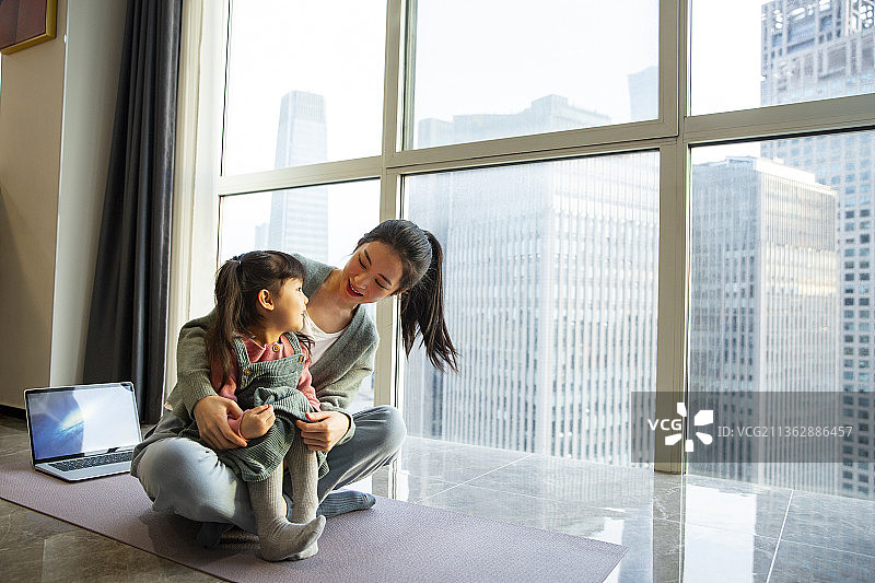 年轻母女在客厅做运动玩耍图片素材