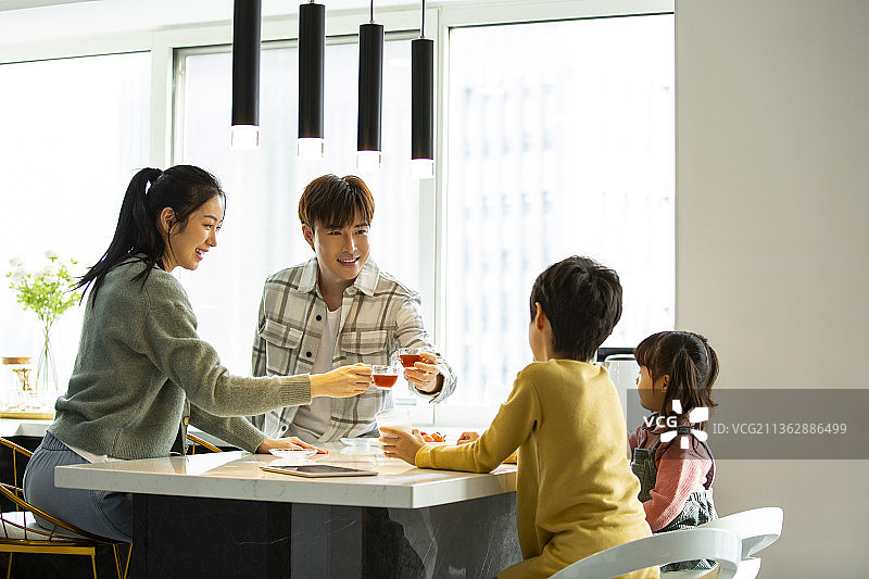 一家四口在开敞厨房休息聊天图片素材