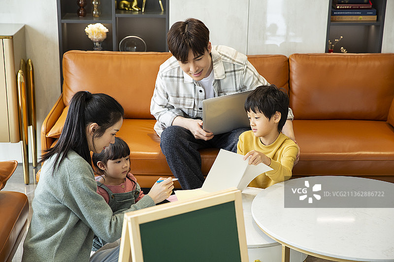 幸福一家四口在客厅学习和工作图片素材