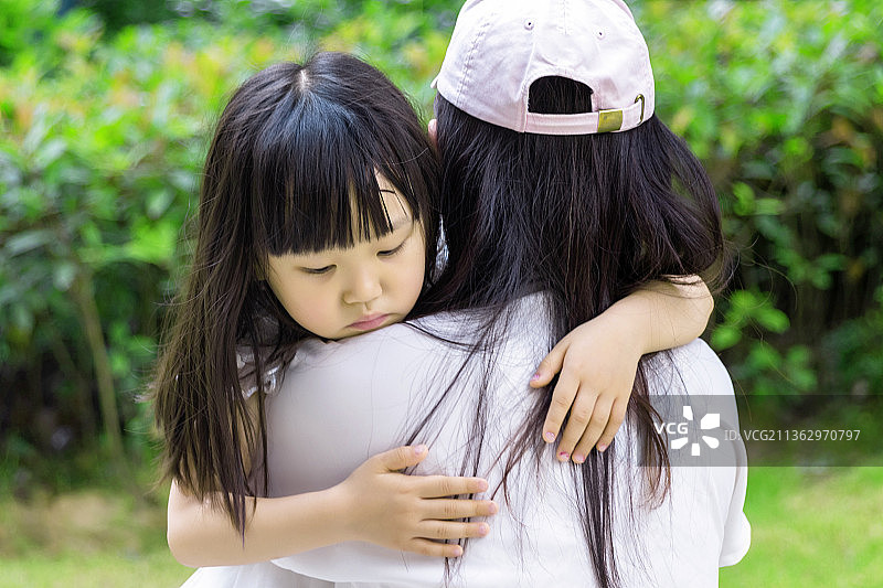 伤心的小女孩搂着妈妈图片素材