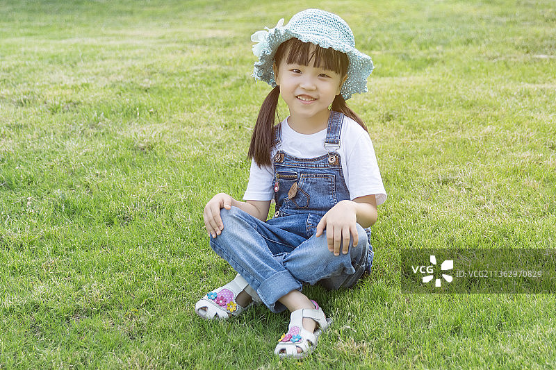 坐在户外草地上的小女孩图片素材