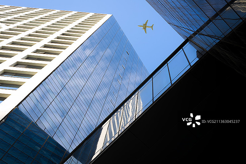 飞机飞过摩天大楼图片素材