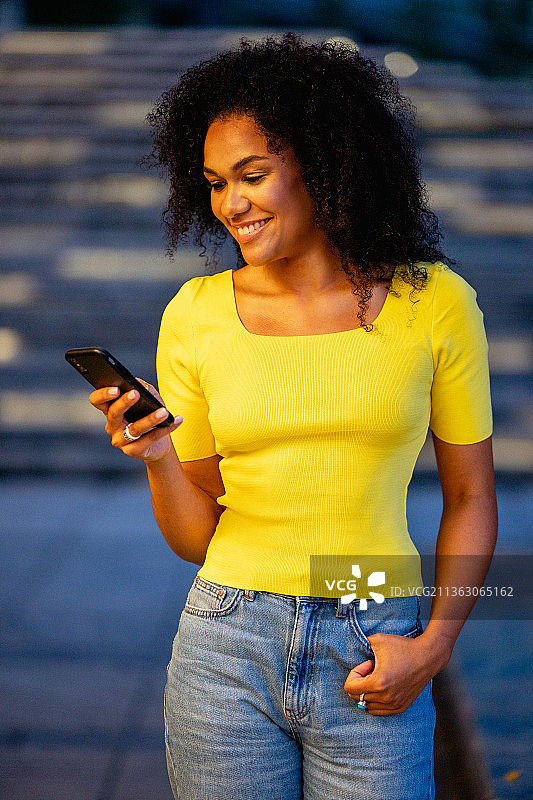 身穿黄色T恤的城市灯光背景女子图片素材