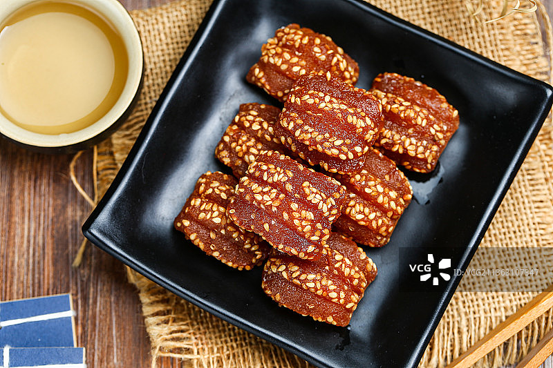 蜜三刀放在黑色盘子里图片素材