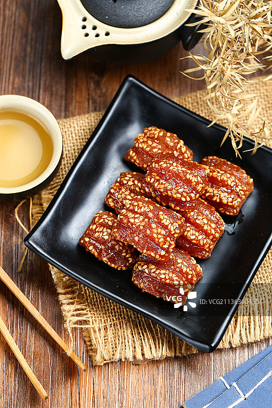 蜜三刀放在黑色盘子里图片素材