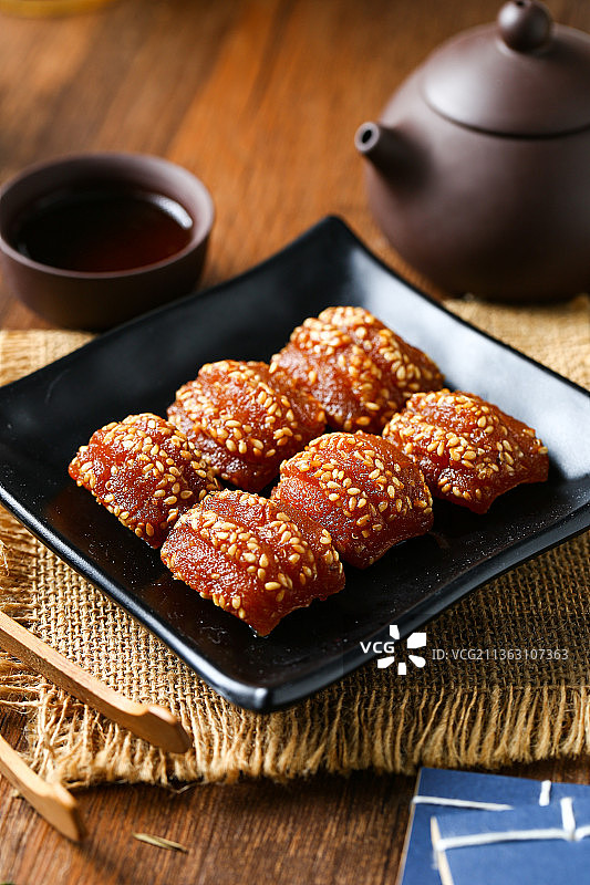 蜜三刀放在黑色盘子里图片素材