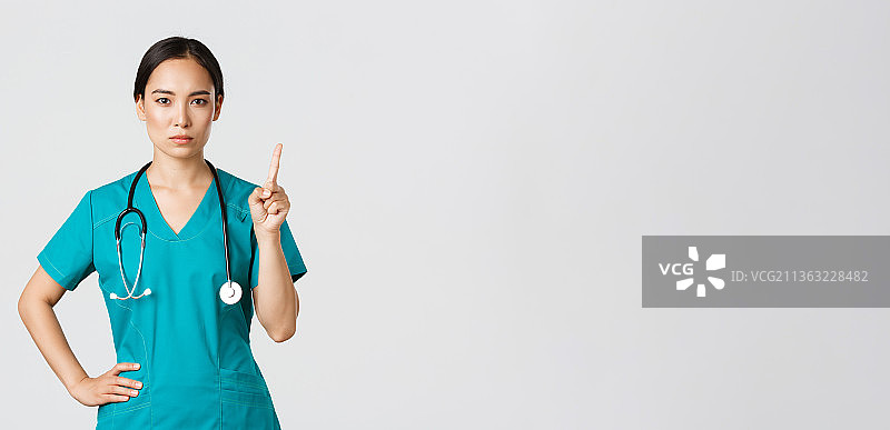 女医生拿着听诊器，站在白色背景前图片素材