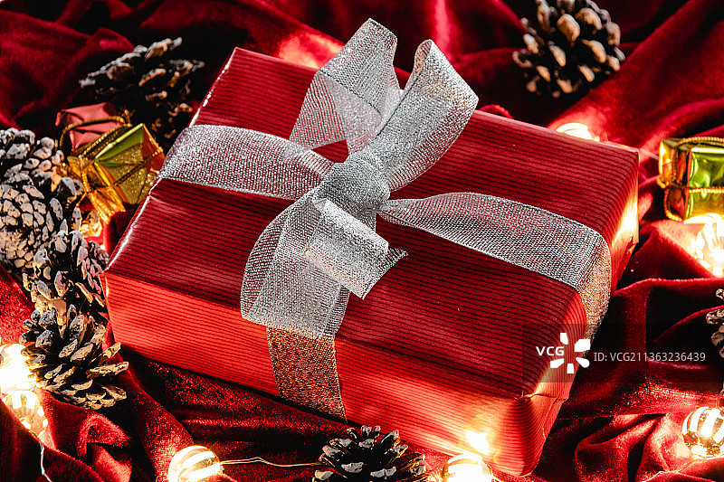红色天鹅绒上的圣诞礼物和装饰品图片素材