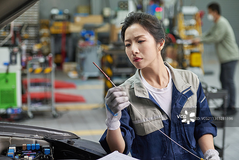 韩国汽车修理店：汽车机械师检查引擎图片素材
