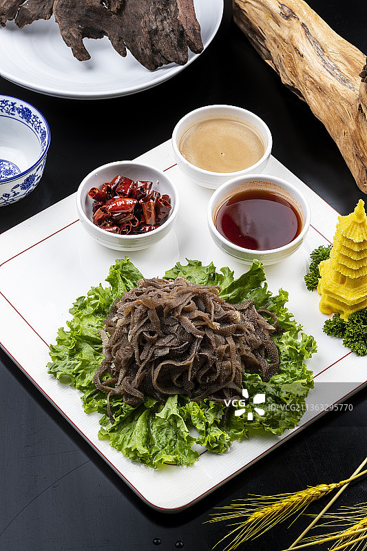 方形瓷盘装的京城爆肚摆放在黑色背景上图片素材