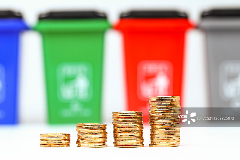 硬币放在垃圾分类垃圾桶前图片素材