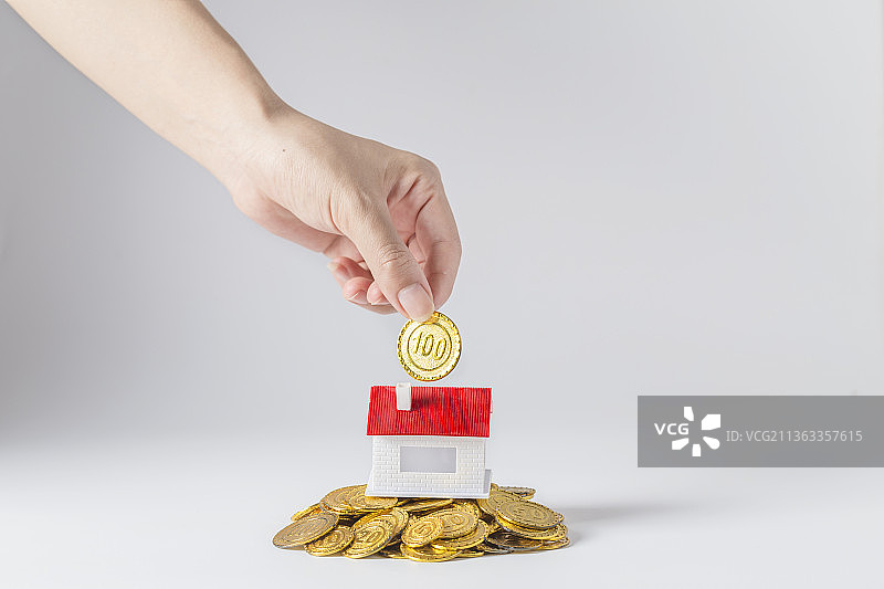 白色背景下向房子模型投放金币图片素材