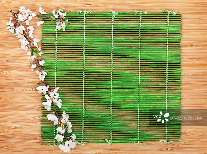 竹席上的樱花树枝，高角度拍摄的桌面花卉图片素材