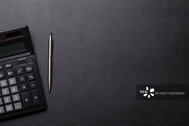 带计算器和笔的办公室皮革桌图片素材