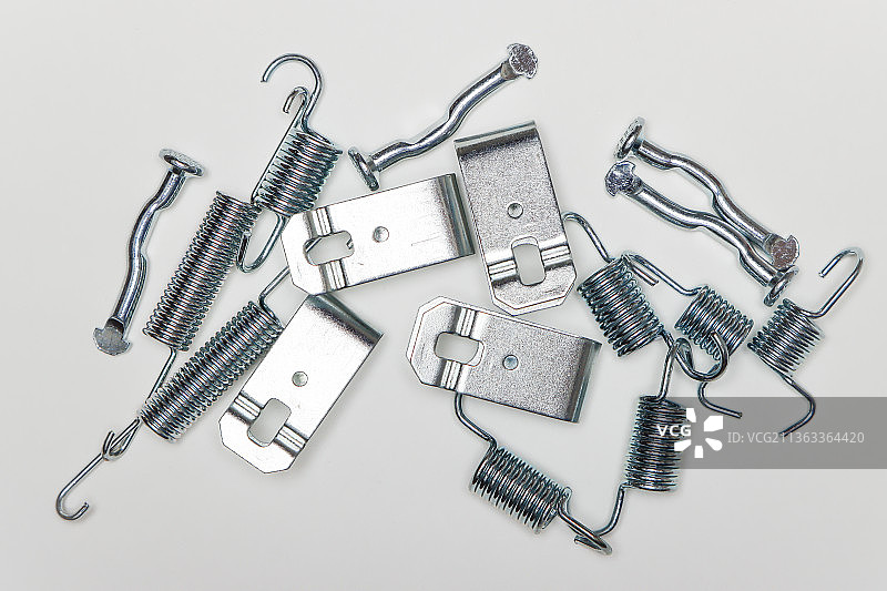 桌子上的金属手指、板材和弹簧，汽车维修零件图片素材