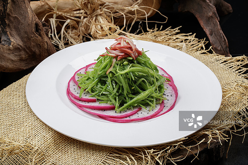 圆形瓷盘装的火龙果青瓜苗摆放在麻布垫子上图片素材