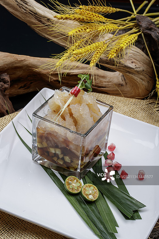 玻璃方盅装的老醋蛰头摆放在樟木砧板上图片素材