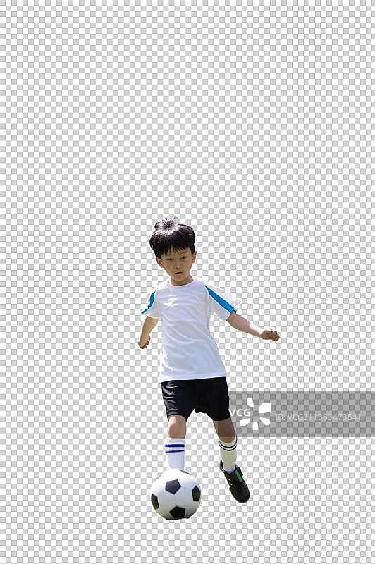 一个男孩正在足球场上踢球图片素材
