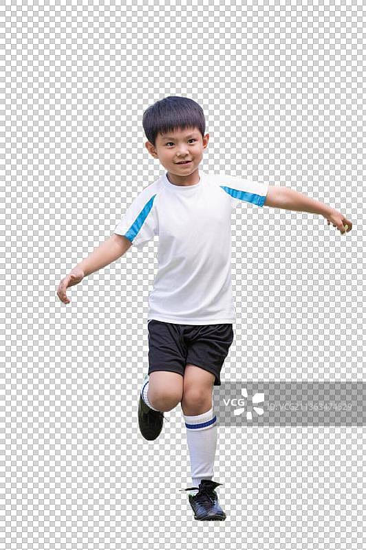 一个男孩在足球场上踢球图片素材