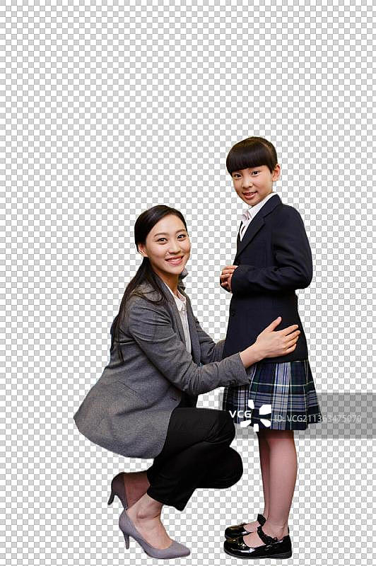 女教师正在帮小学女生试穿校服图片素材