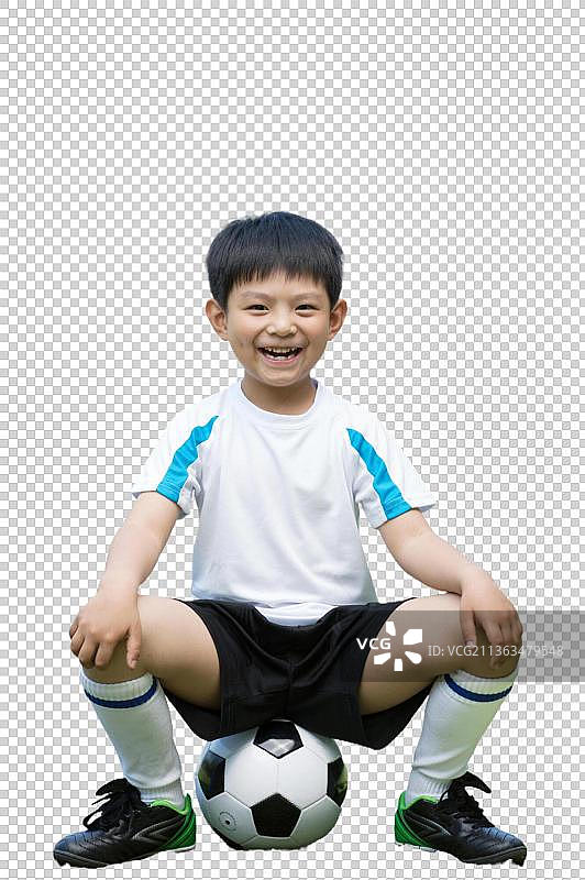 男孩兴奋的坐在足球上图片素材